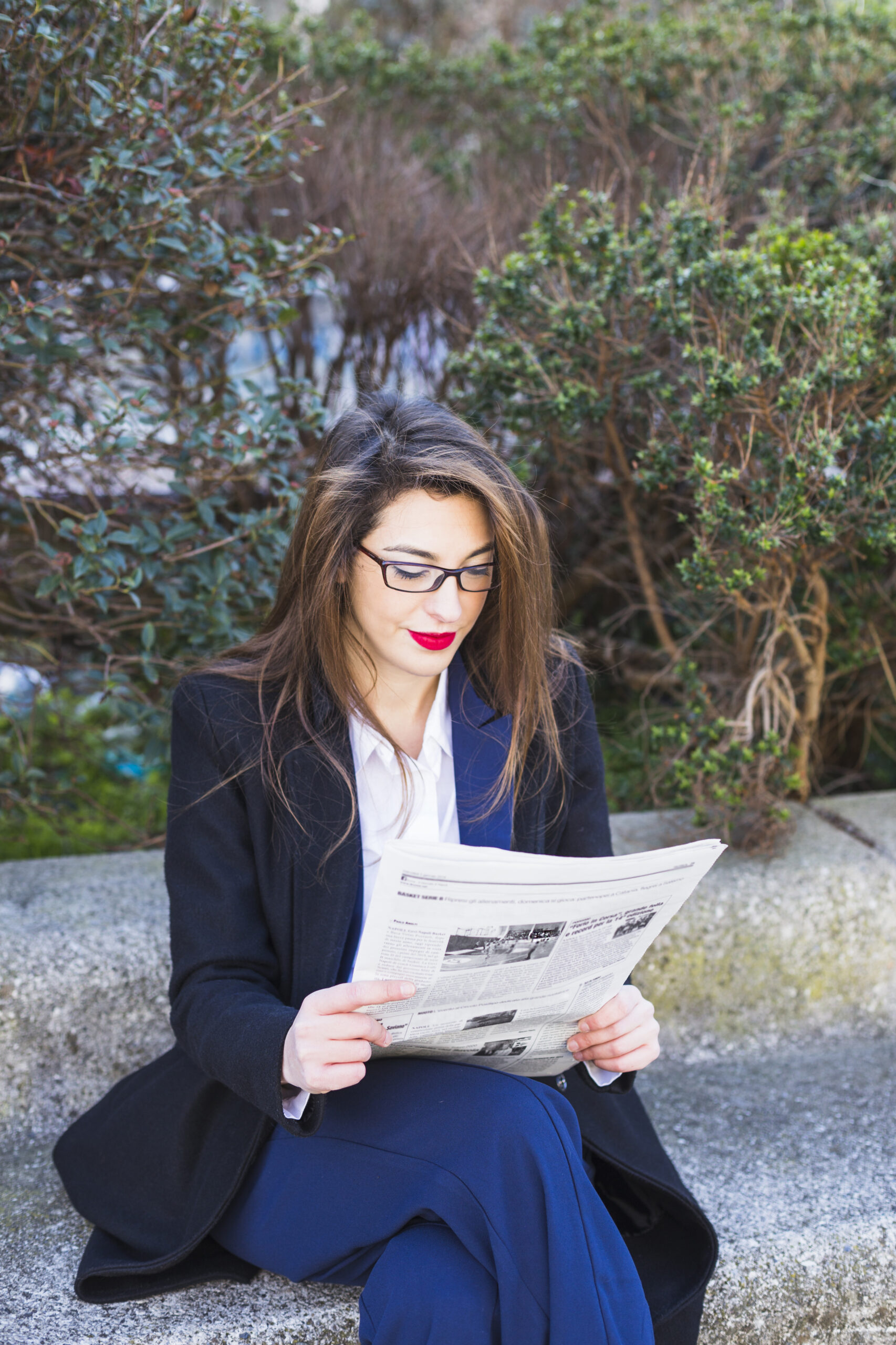 business-woman-reading-newspaper-outside